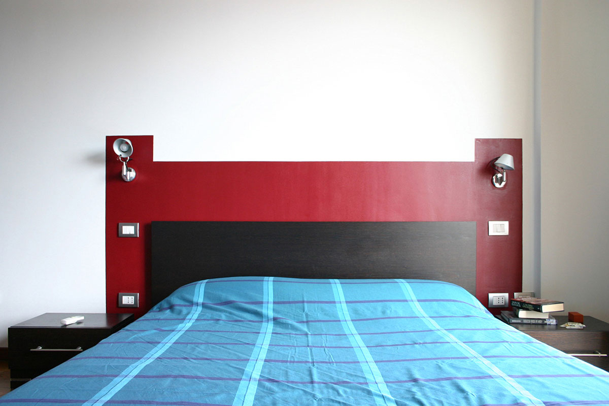 Colore arredo - Un passepartout di colore che racchiude la testata del letto e le applique